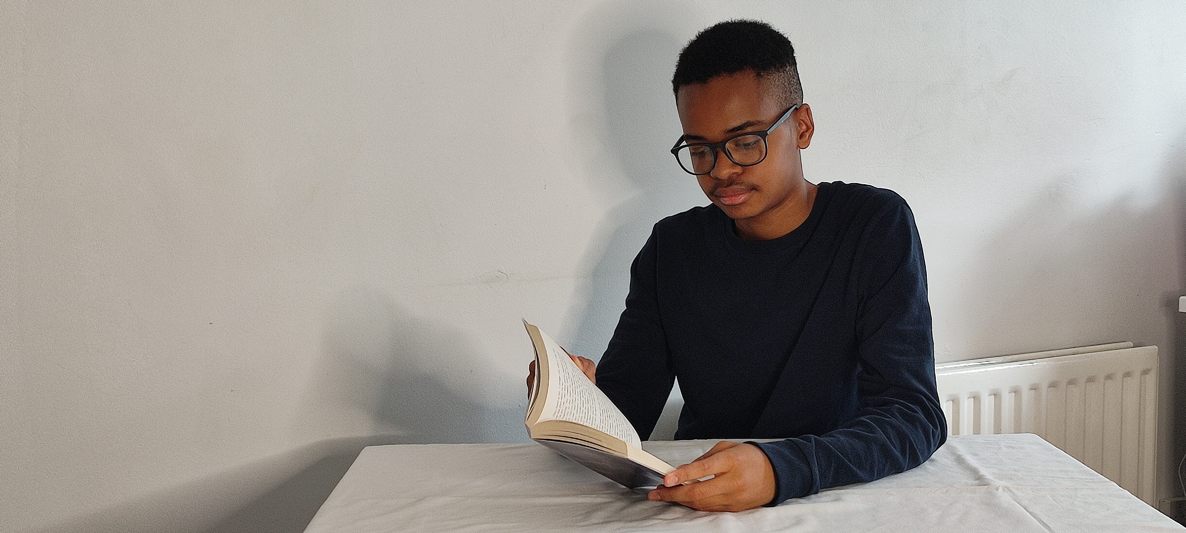 Elijah Mbale reading a book