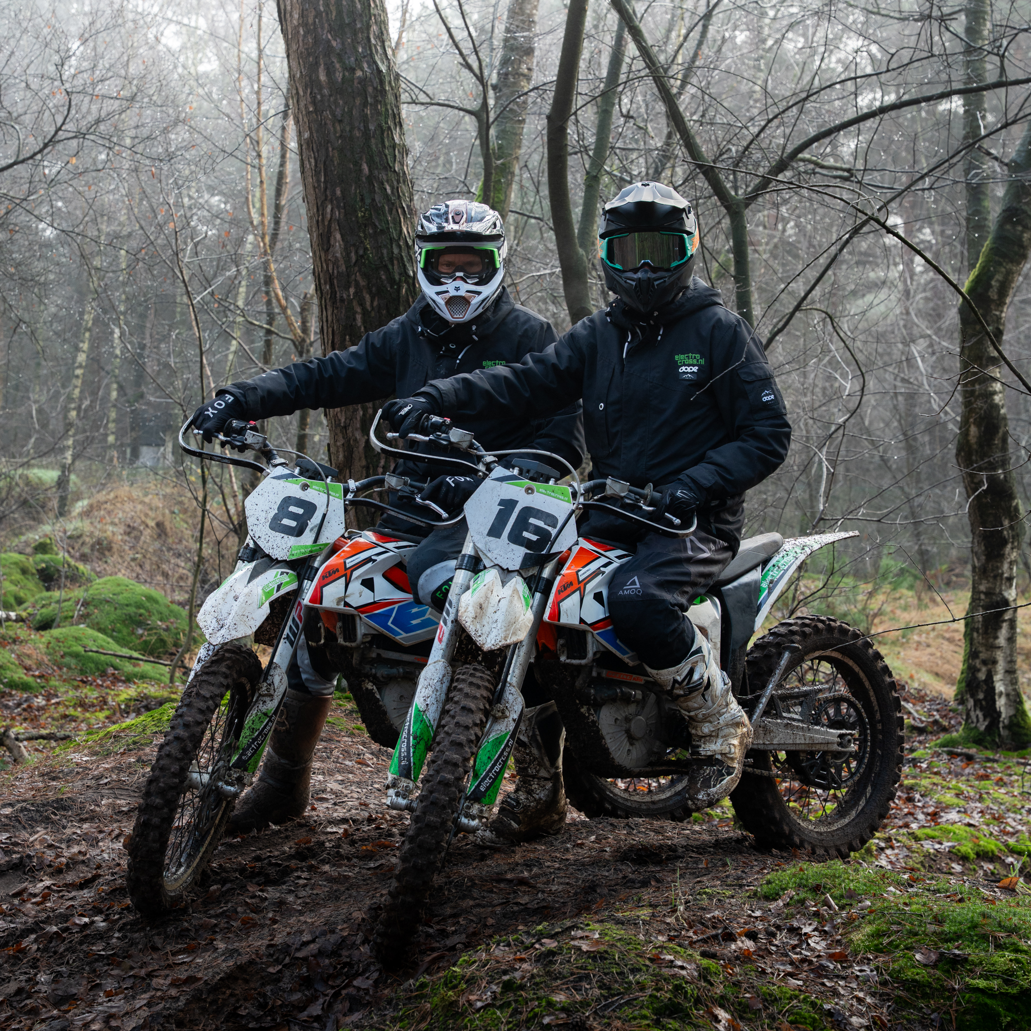 Enduro crossers die in het bos poseren.
