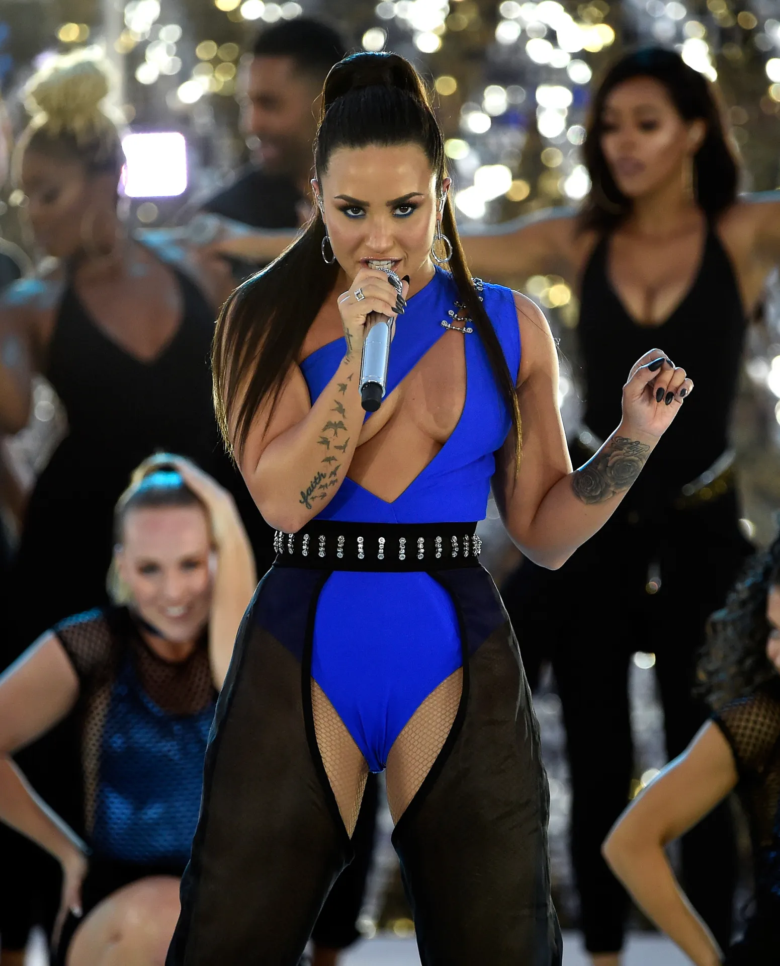 Demi Levato singing, surrounded by dancers, at the MTV VMA Awards.