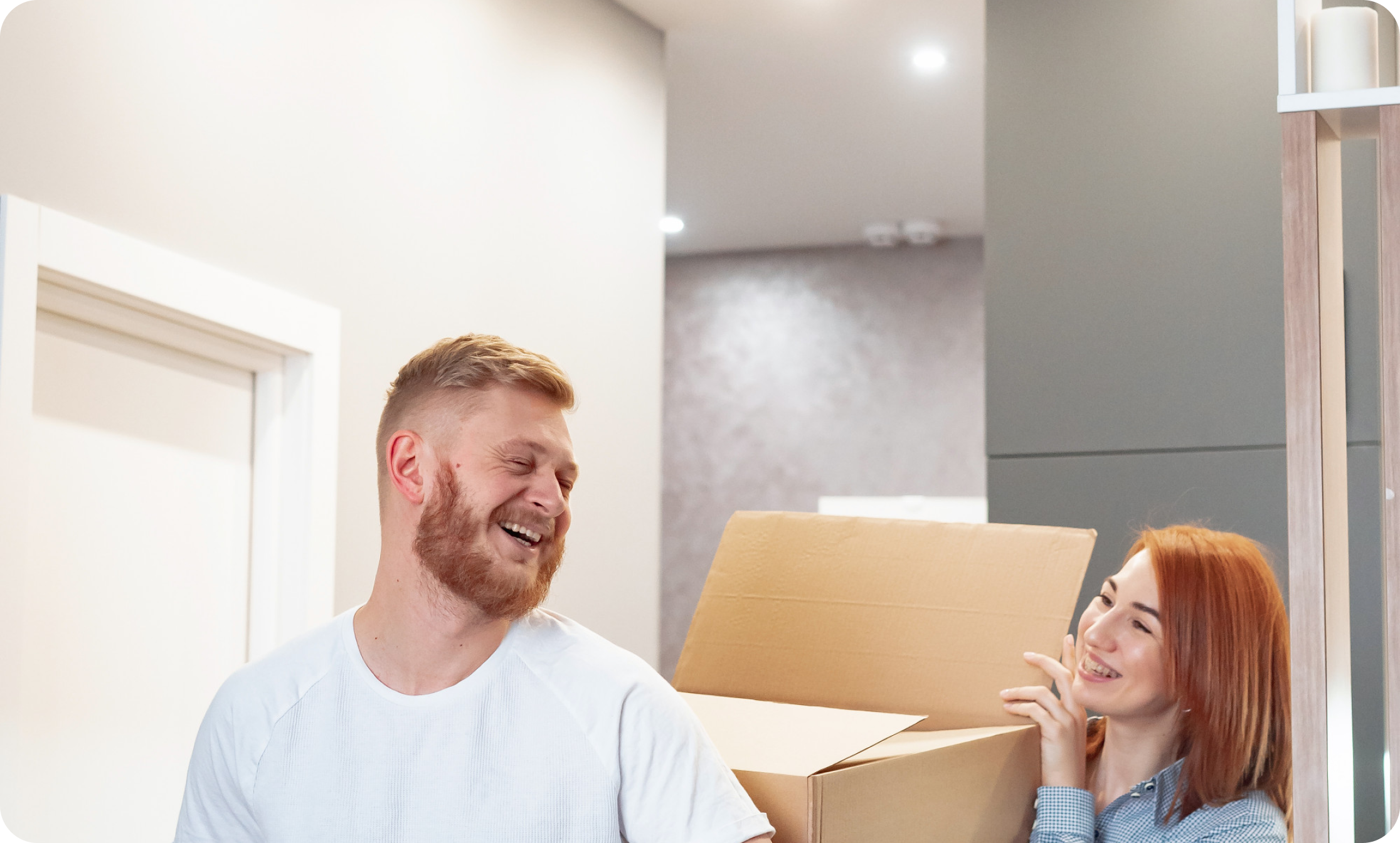 Man smiling in his newly moved-into flat, standing among unpacked boxes—enjoying the comfort and satisfaction of a successful relocation with IMG Removals in Birmingham.