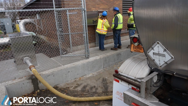 Septage receiving workers connect truck to station.