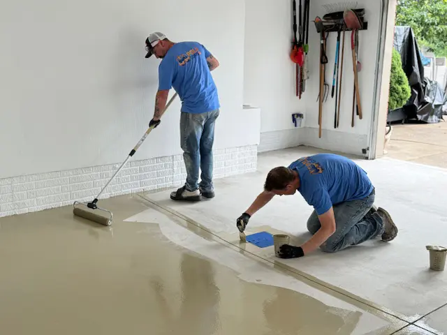 Dan and Nick from Poly Guys, spreading clear polyaspartic coating on a garage floor