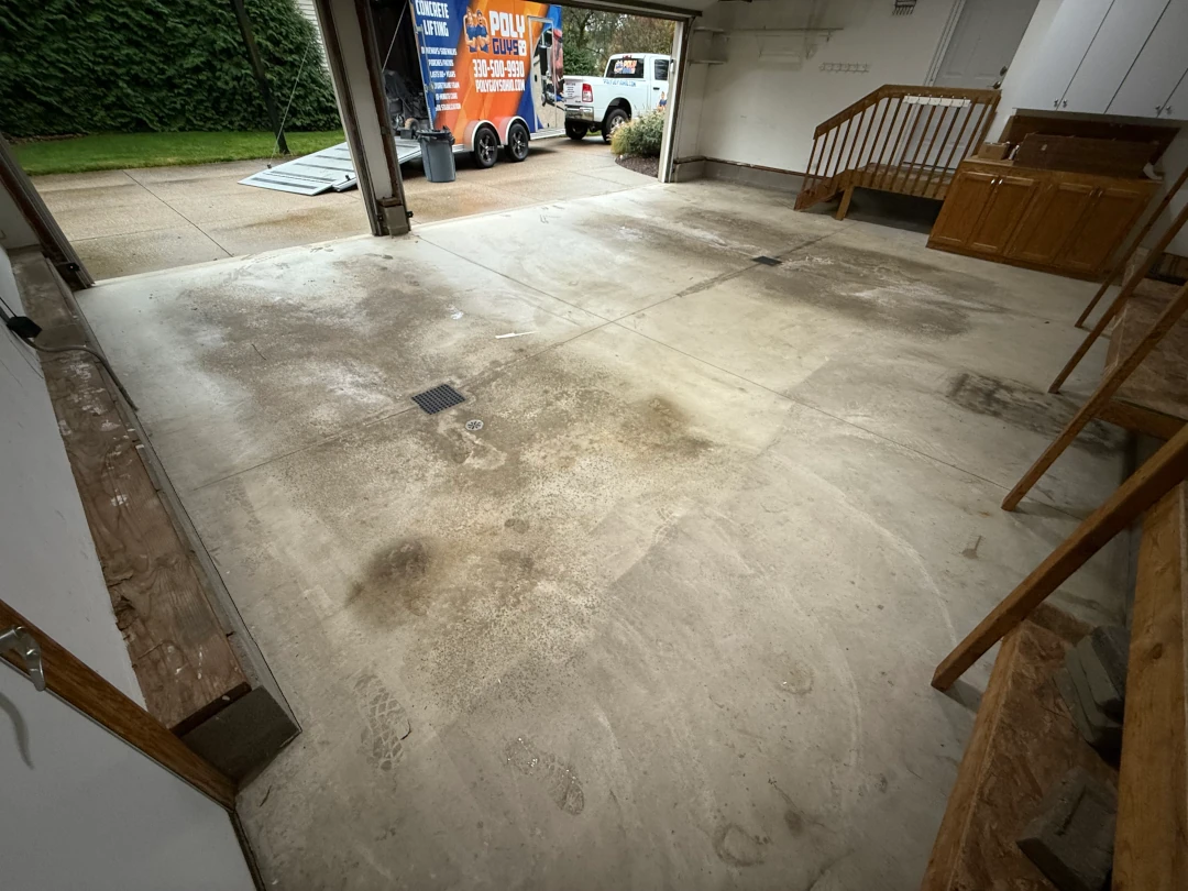 3-car garage concrete floor before coating, showing wear and staining near the entrance.