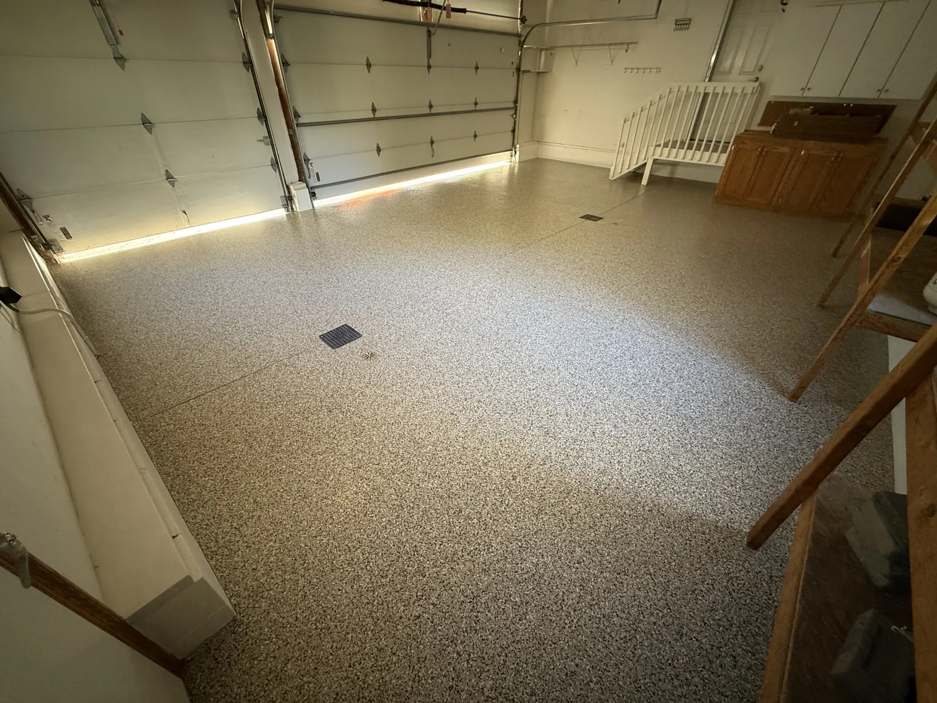 Finished 3-car garage floor with Nutmeg flake polyaspartic coating and clean, glossy finish.