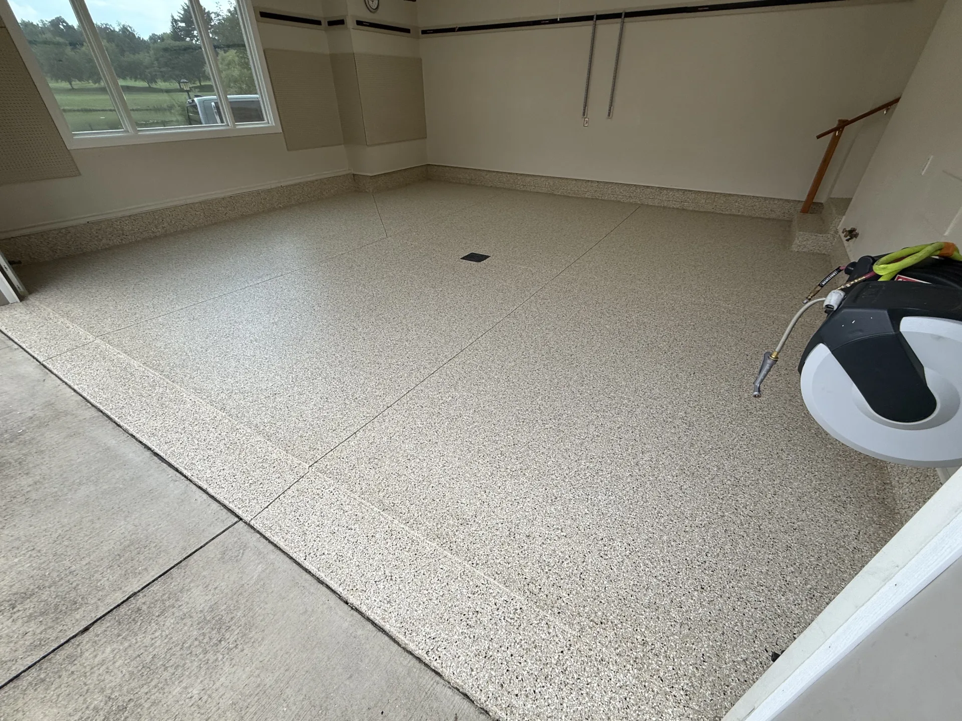 Garage floor after coating with Smoke flake finish near the entry door and clean edges.