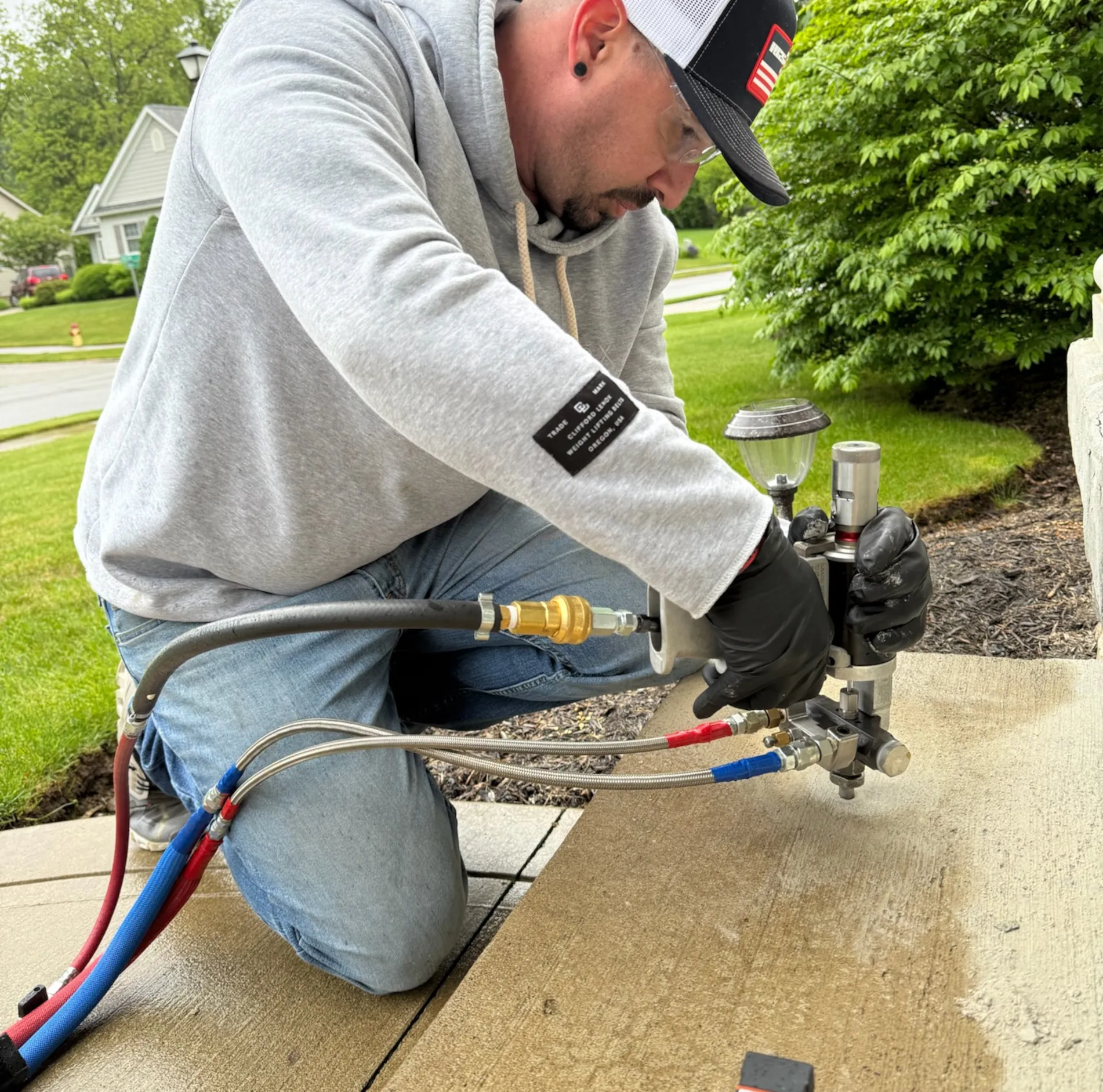 Man using polyurethane foam to lift a concrete patio