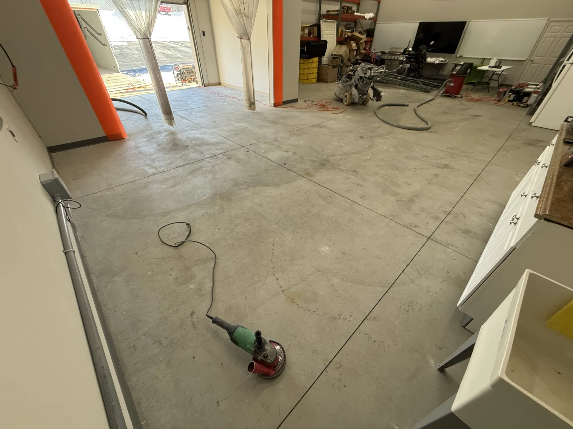 Concrete floor at Keller Construction after diamond grinding and surface preparation, ready for installation of a commercial polyaspartic flake coating system.
