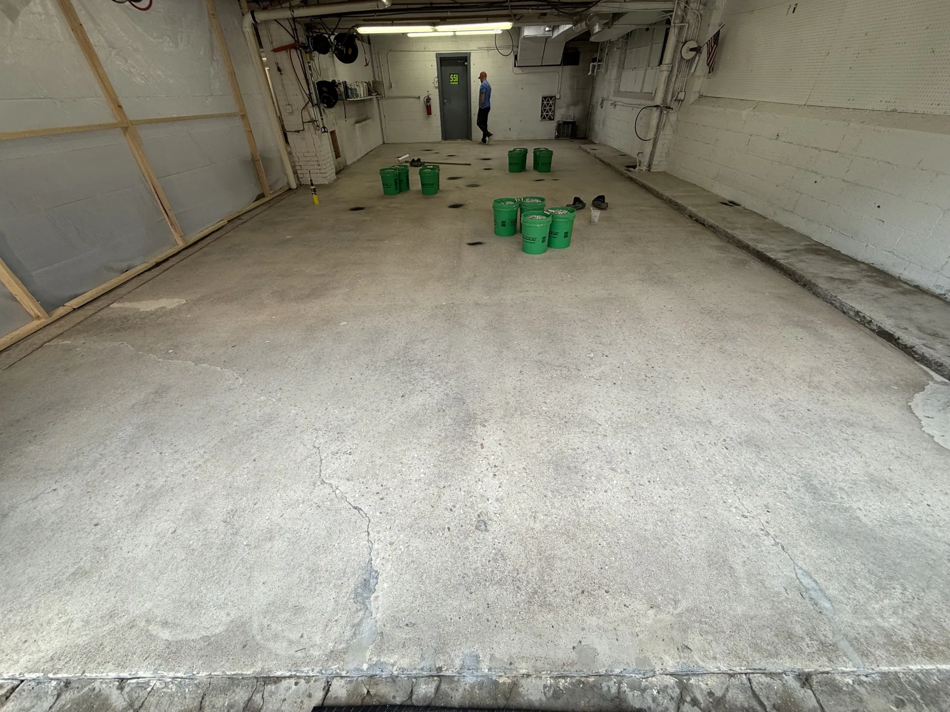 Commercial garage floor after crack and surface repairs, prepared and ready for installation of a polyaspartic flake floor coating system.