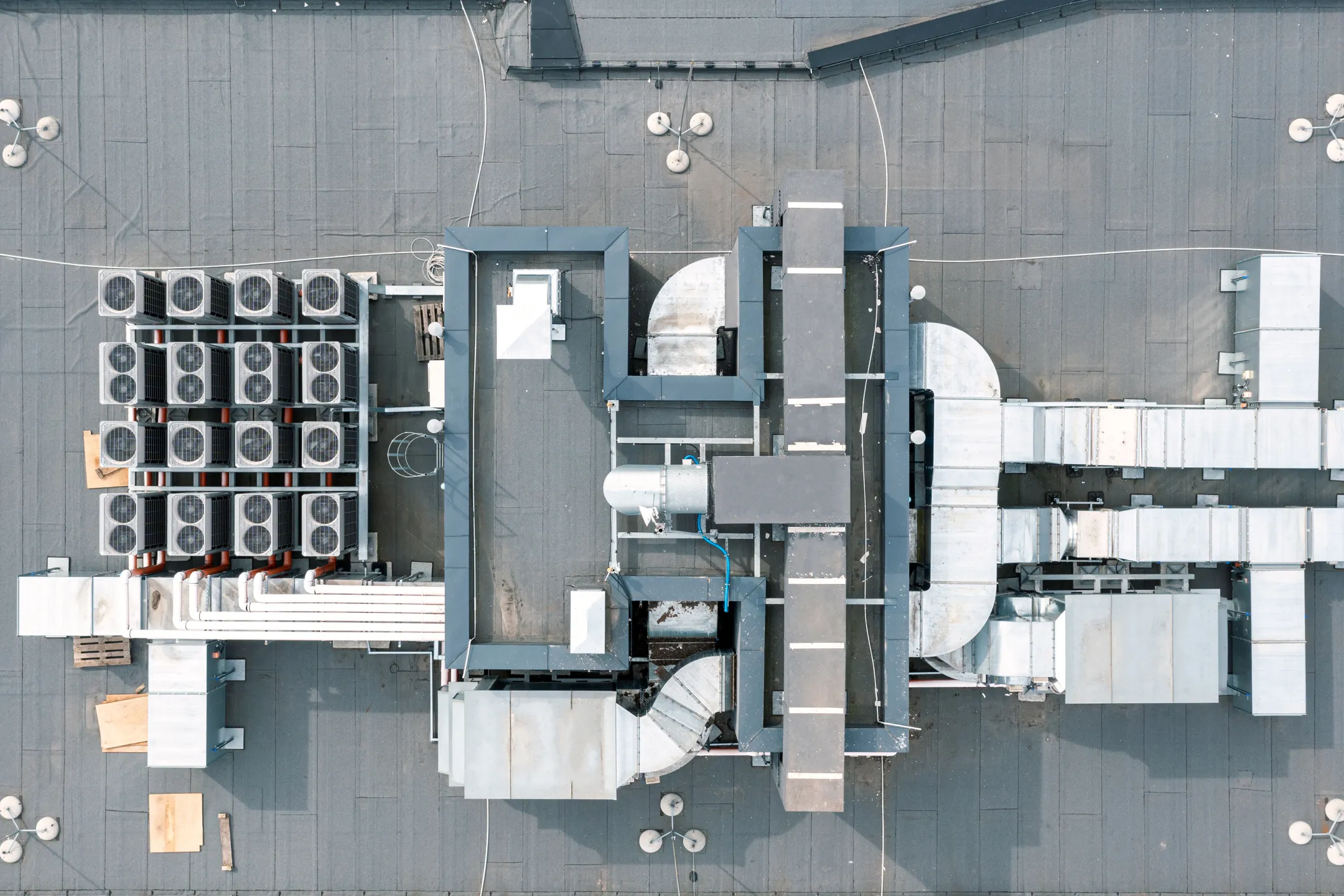 Arial view of the top of a building with large fans from air conditioning units.