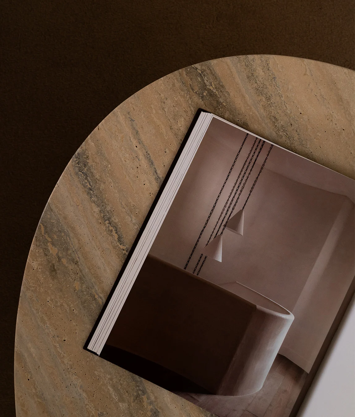 Close-up view of a swimming pool corner with turquoise water, light brown poolside tiles, and speckled stone, with shadows cast across the surface.
