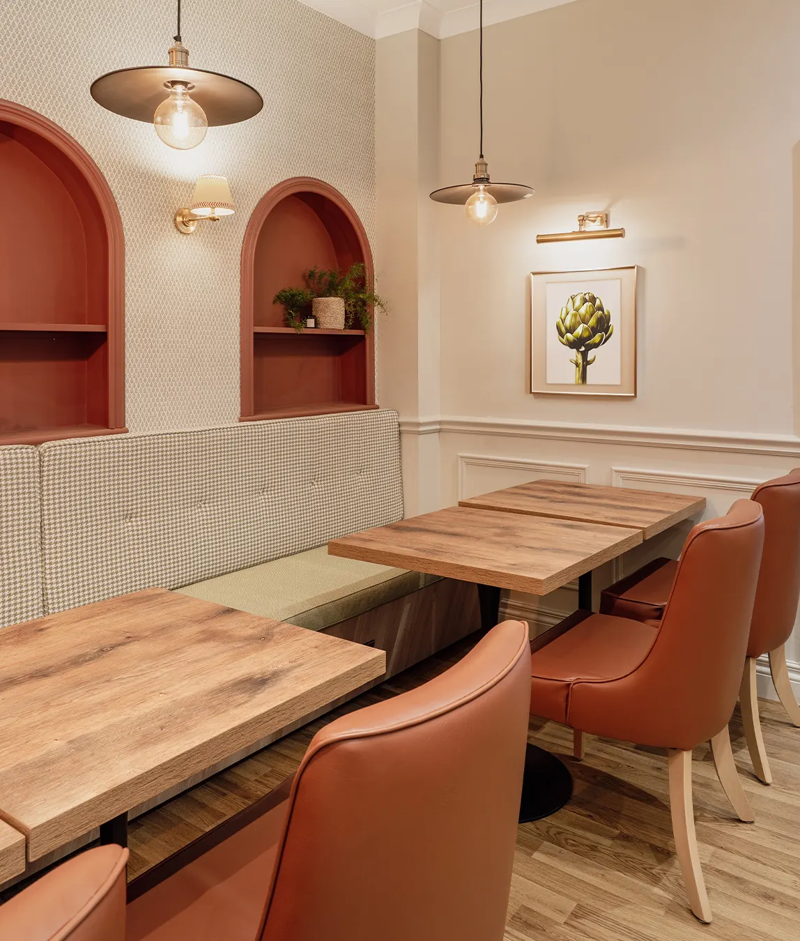 Warm modern living room with dark wood paneling, minimalist shelves, a boucle armchair, and a black marble fireplace.