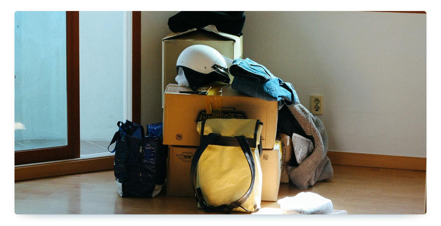 Moving boxes stand in a hallway in front of a white wall