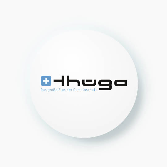 A white circle with a drop shadow features a black and blue logo. The logo, for a company called "Thüga," includes a blue square with a white cross and the text "Das große Plus der Gemeinschaft" (the big plus of cummunity) below it.