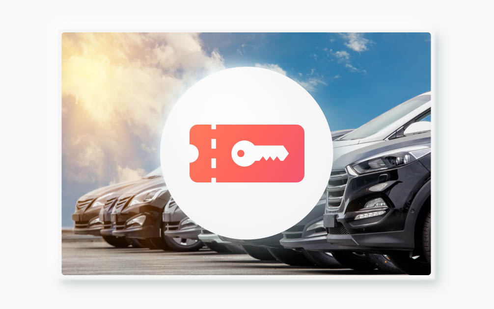 This image shows the front ends of several cars parked side-by-side. A round, red icon with a white key on it is in the center of the image. The sun is shining in the background.