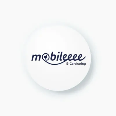 A simple, round icon with the logo for "mobileeee E-Carsharing." The logo features a charging plug integrated into the word "mobileeee."