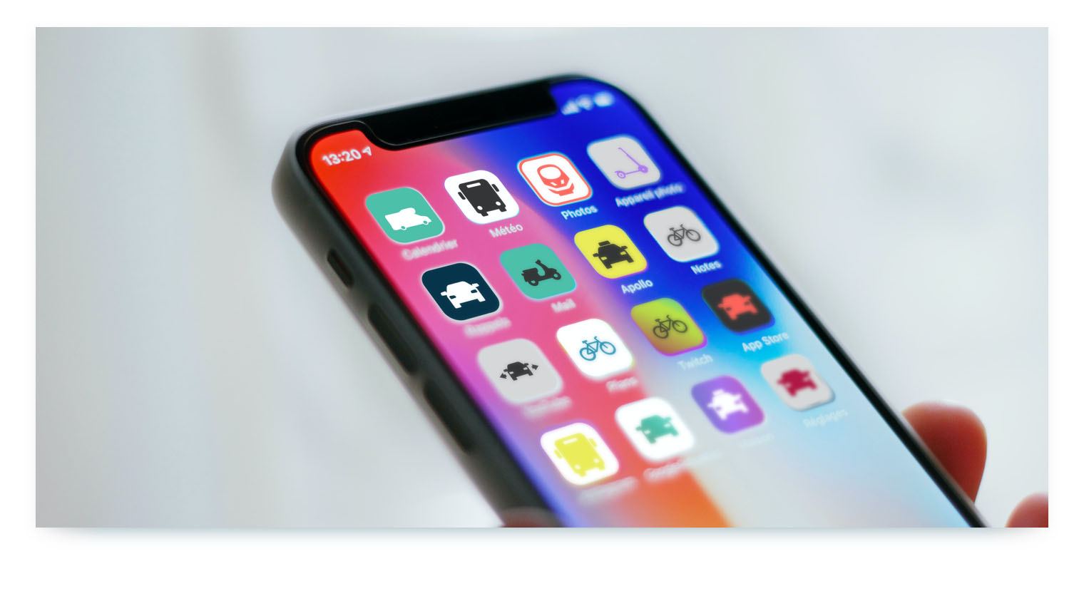 A close-up shot of an iPhone home screen with several apps related to mobility. Icons for different types of transport like buses, cars, and bikes are arranged on the screen, representing various shared mobility services accessible from a single device.