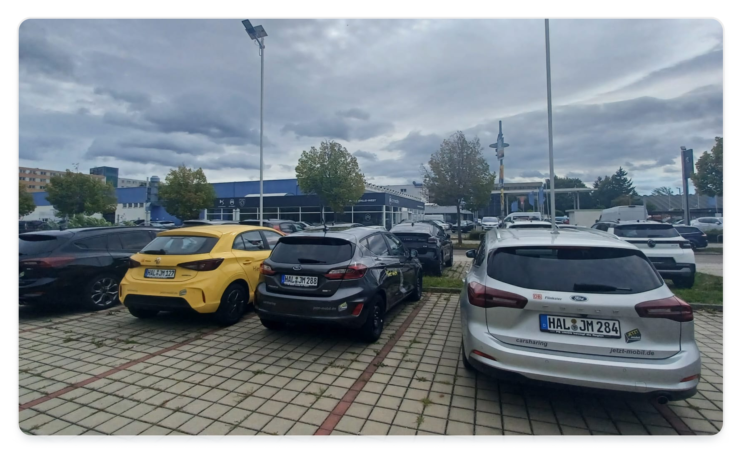 Several cars are parked on the parking spot at a workshop of the car dealership because they are offered as service rental vehicles for dealership customers