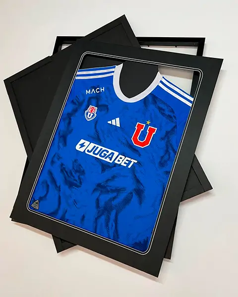 Camiseta azul del equipo de fútbol Universidad de Chile en un marco negro.