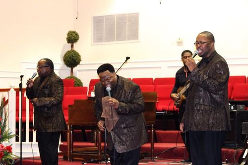 Image of a quartet of musicians wearing matching suits.