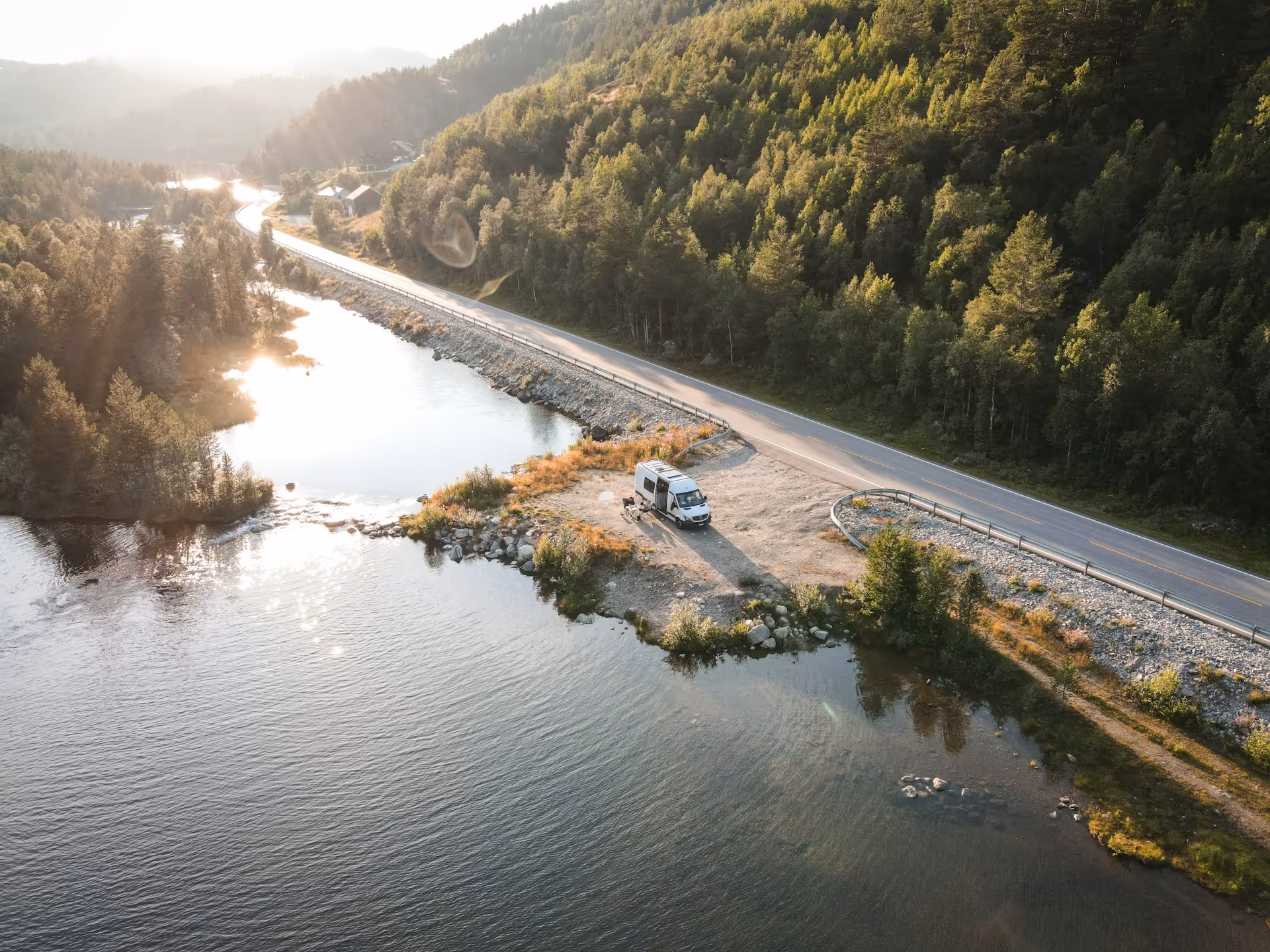 Een luxe camper van Camper Casa staat off-grid geparkeerd aan het water midden in de natuur, genietend van ultieme vrijheid.