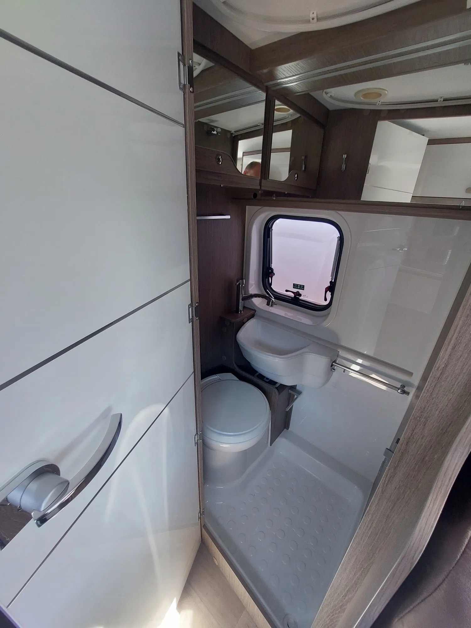 Compact badruimte met toilet, wastafel en raam in de in Chausson V217 camper.