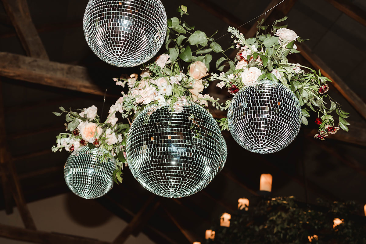 Disco balls with custom florals adorning the dance floor.