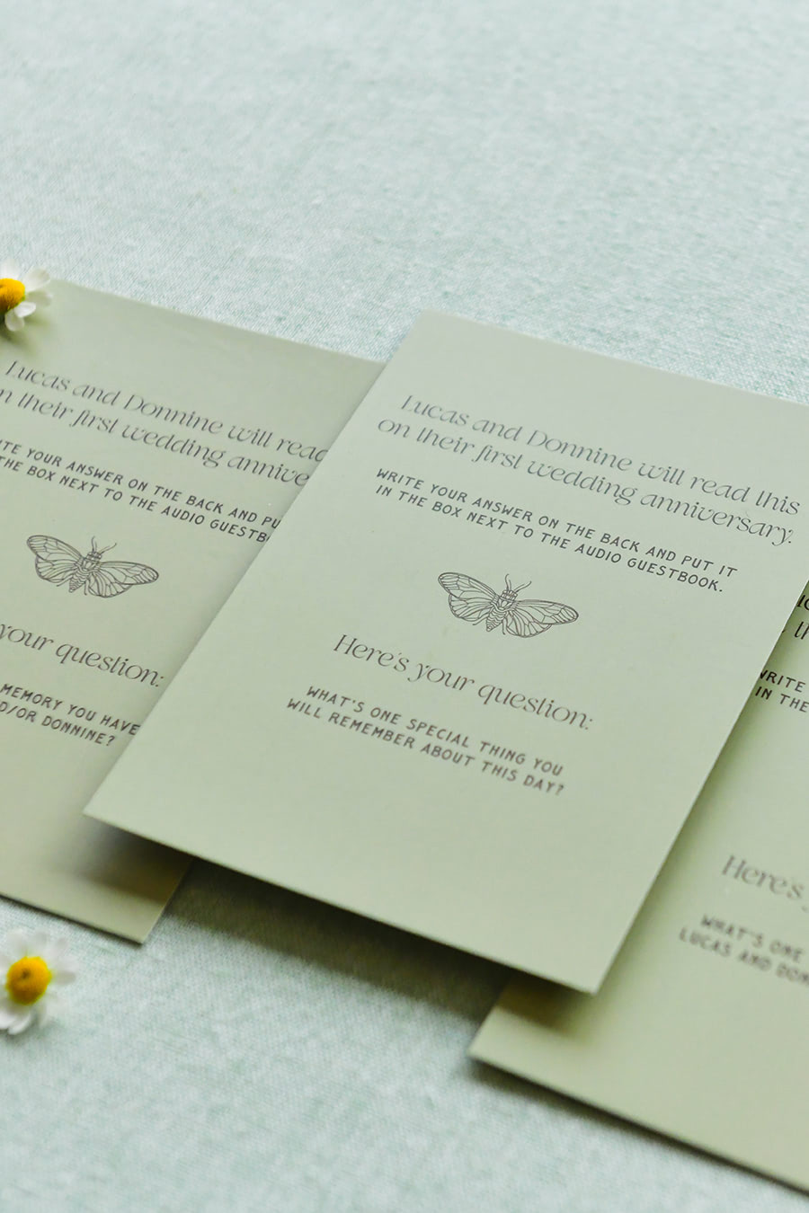Three green table cards with reflective questions for people to write their memories of the day on.