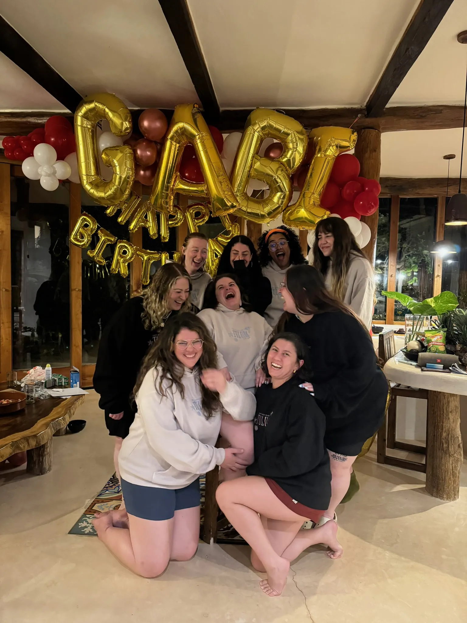 Group of friends in matching sweatshirts laughing.