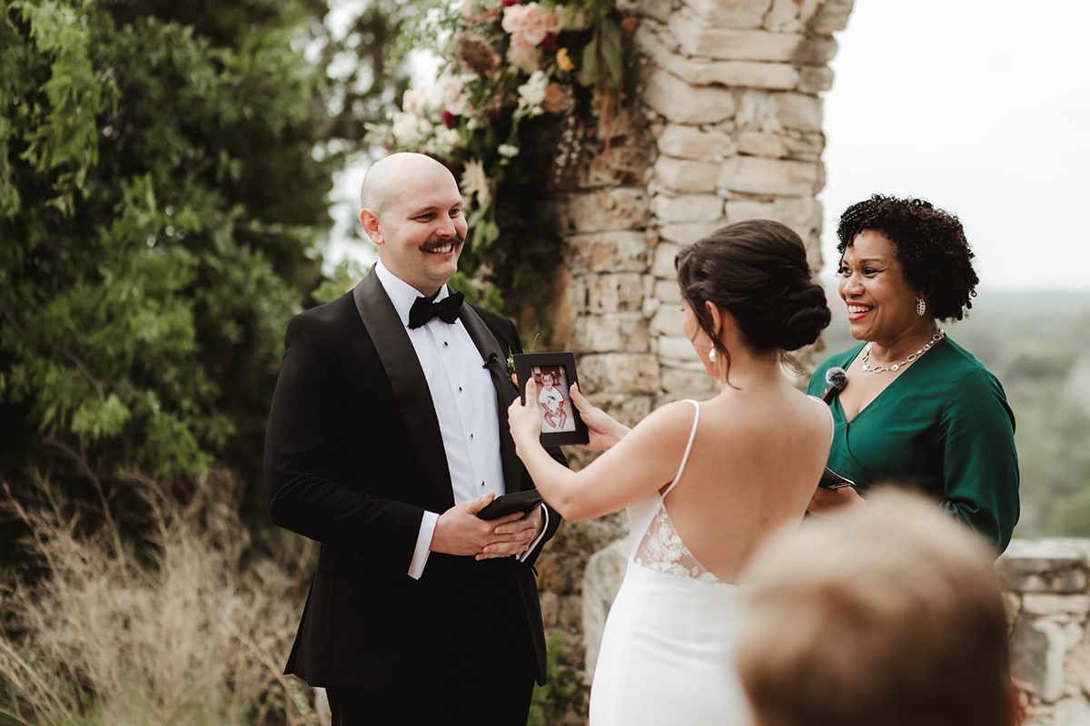 A couple at the altar exchanges a photo of themselves as children as part of their wedding ceremony.
