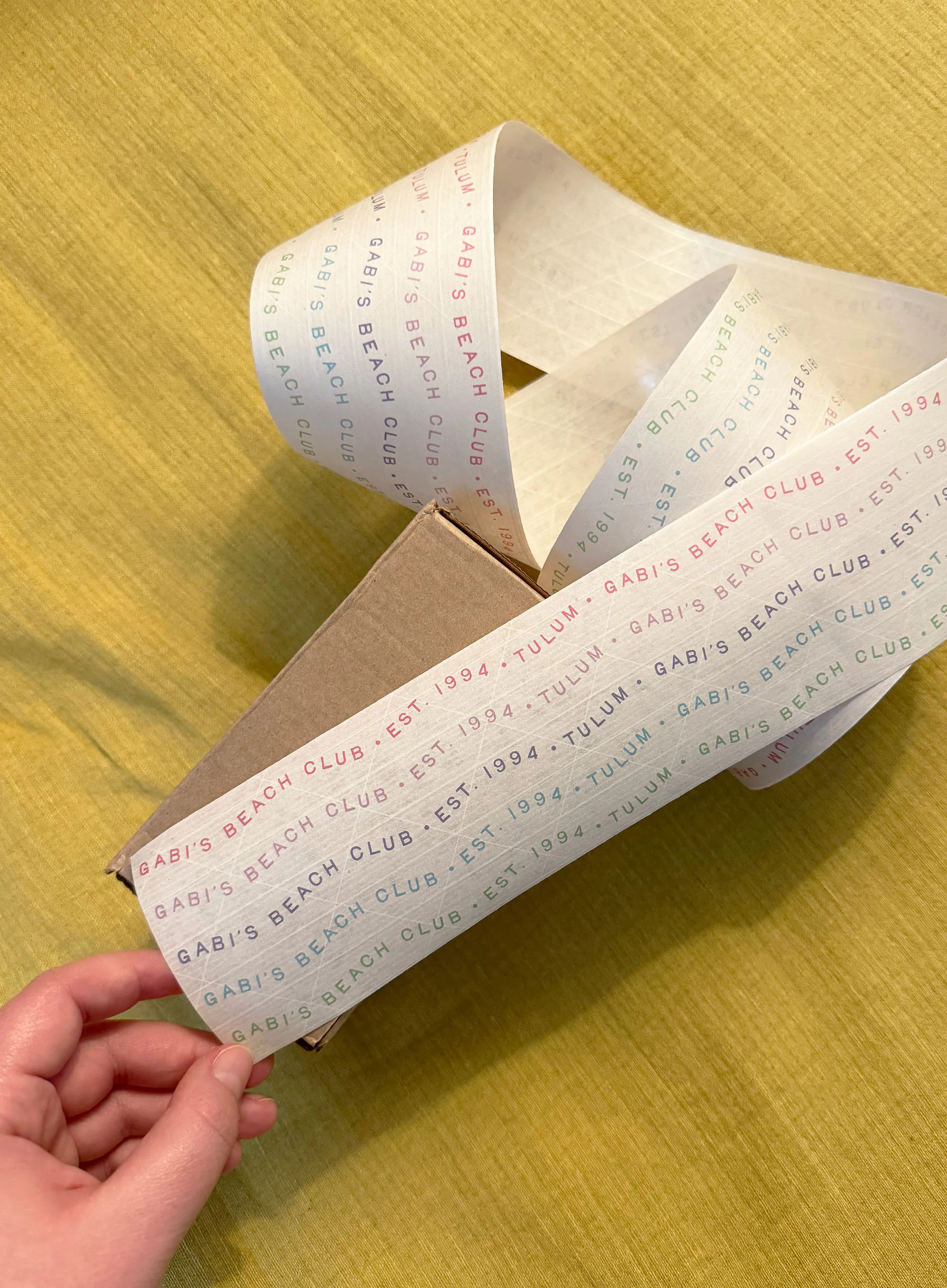 Hand taping custom packing tape on a box.