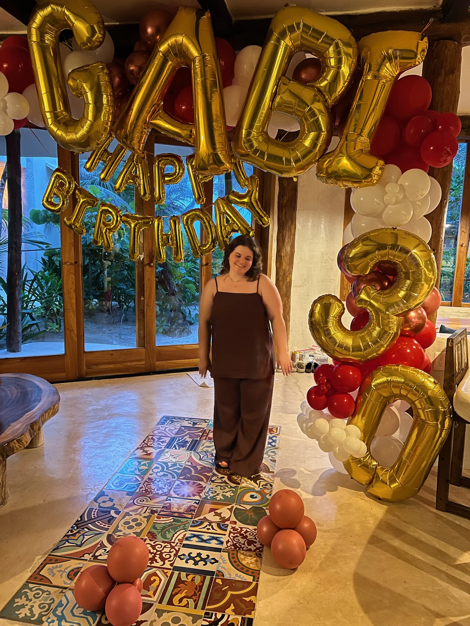 Gabi posing in front of birthday balloons.