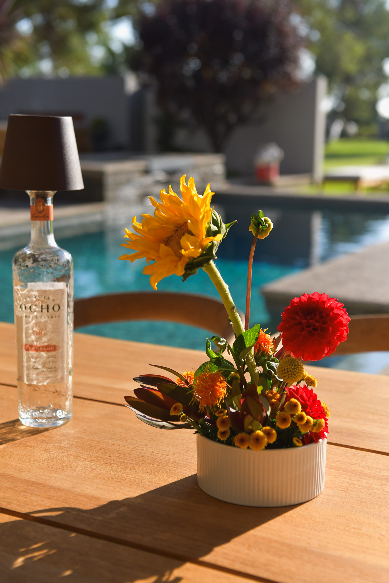 A bottle with a night lamp and a dramatic floral display