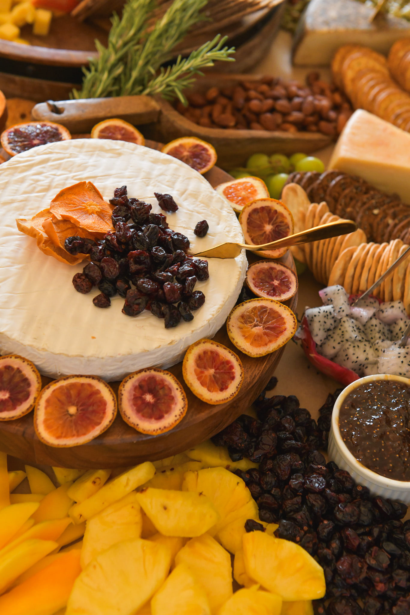 A thick wheel of brie with cheese and crackers adorning all around