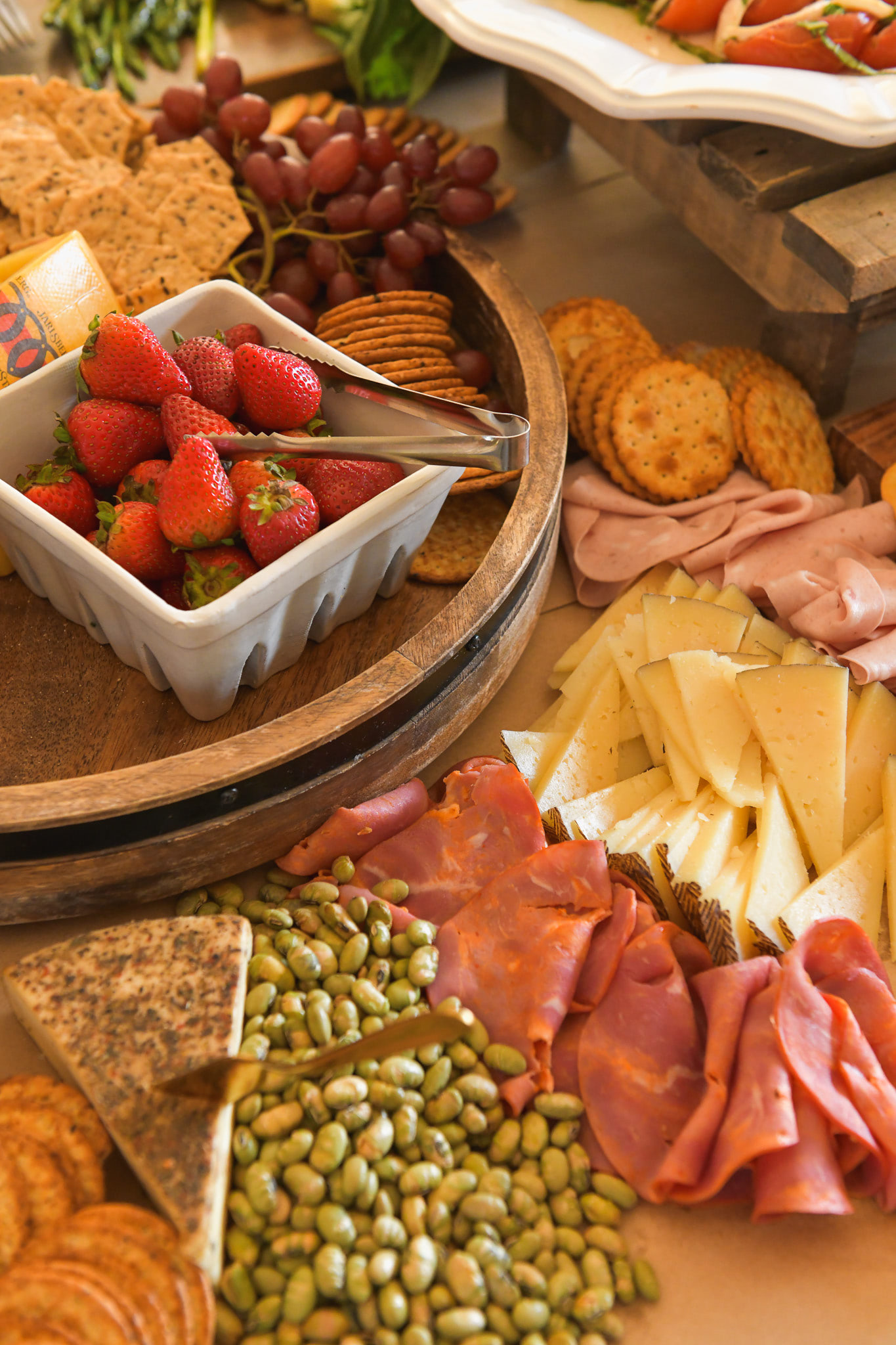 A bed of finger foods like strawberries, cheeses, and nuts