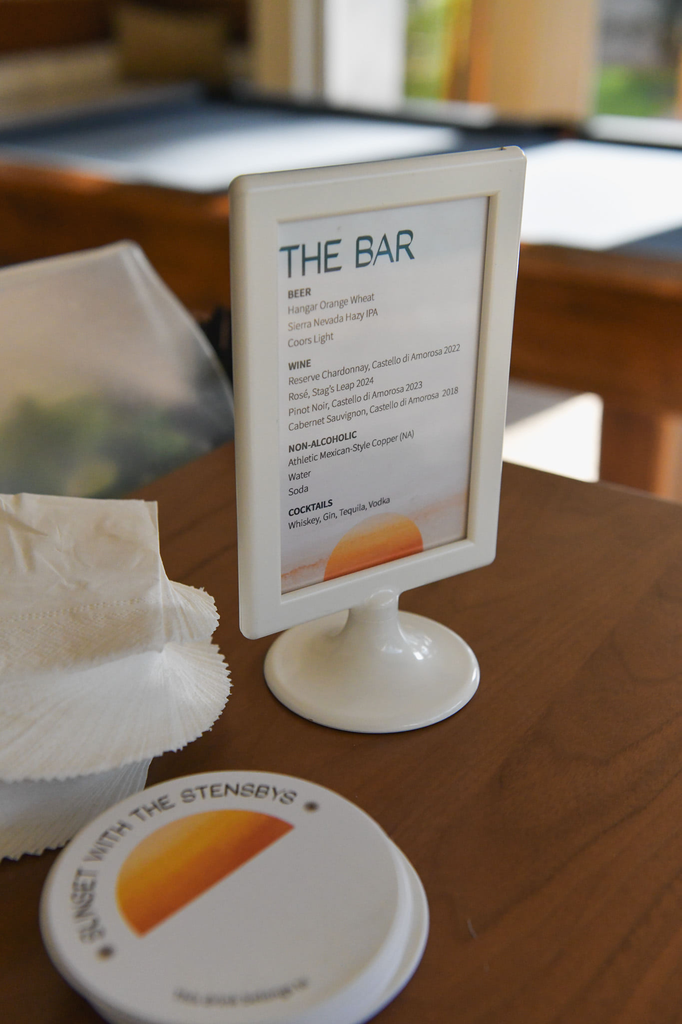 A sign with drink options on the bar