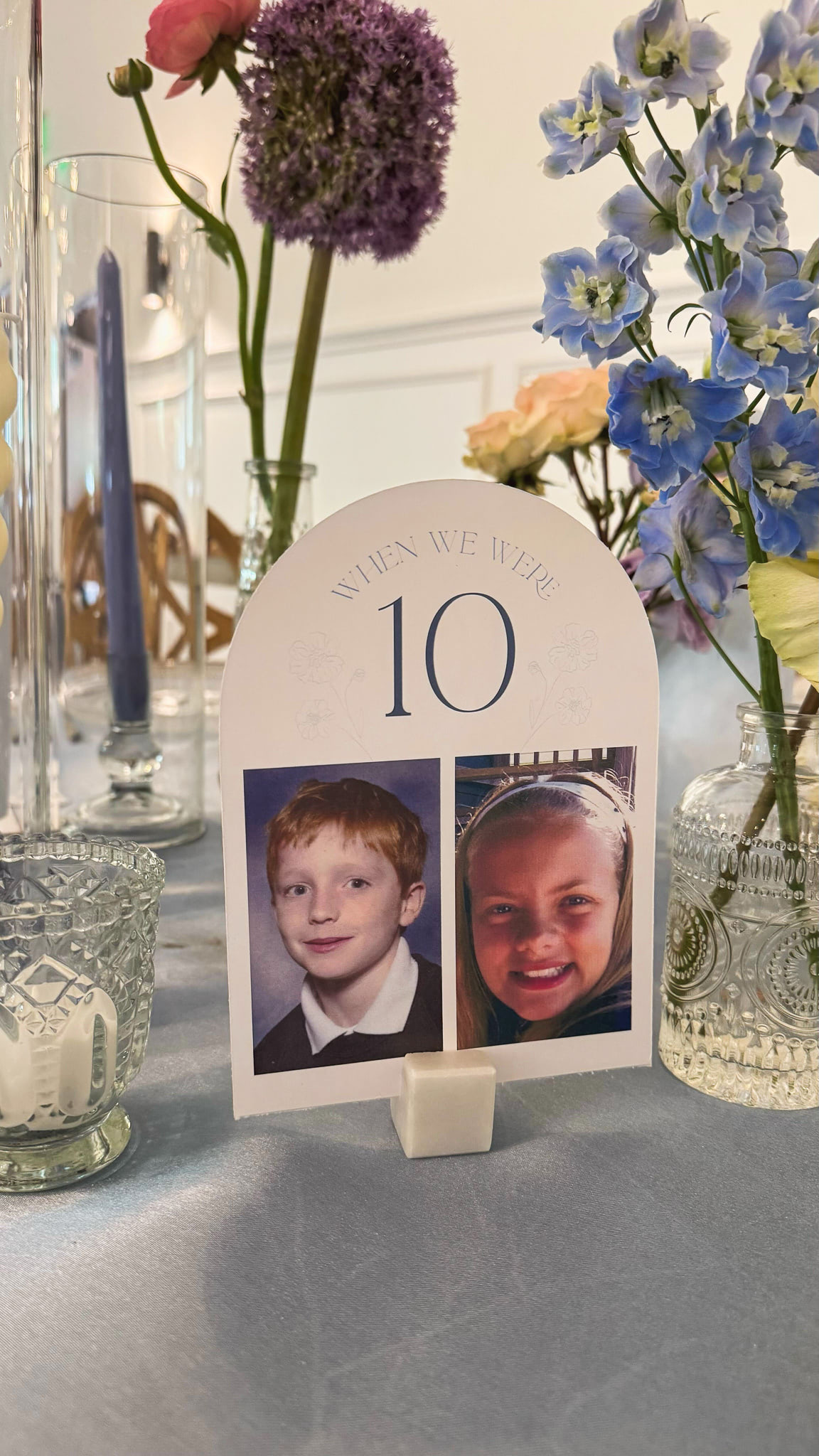 A table number with portraits of the bride and groom when they were 10