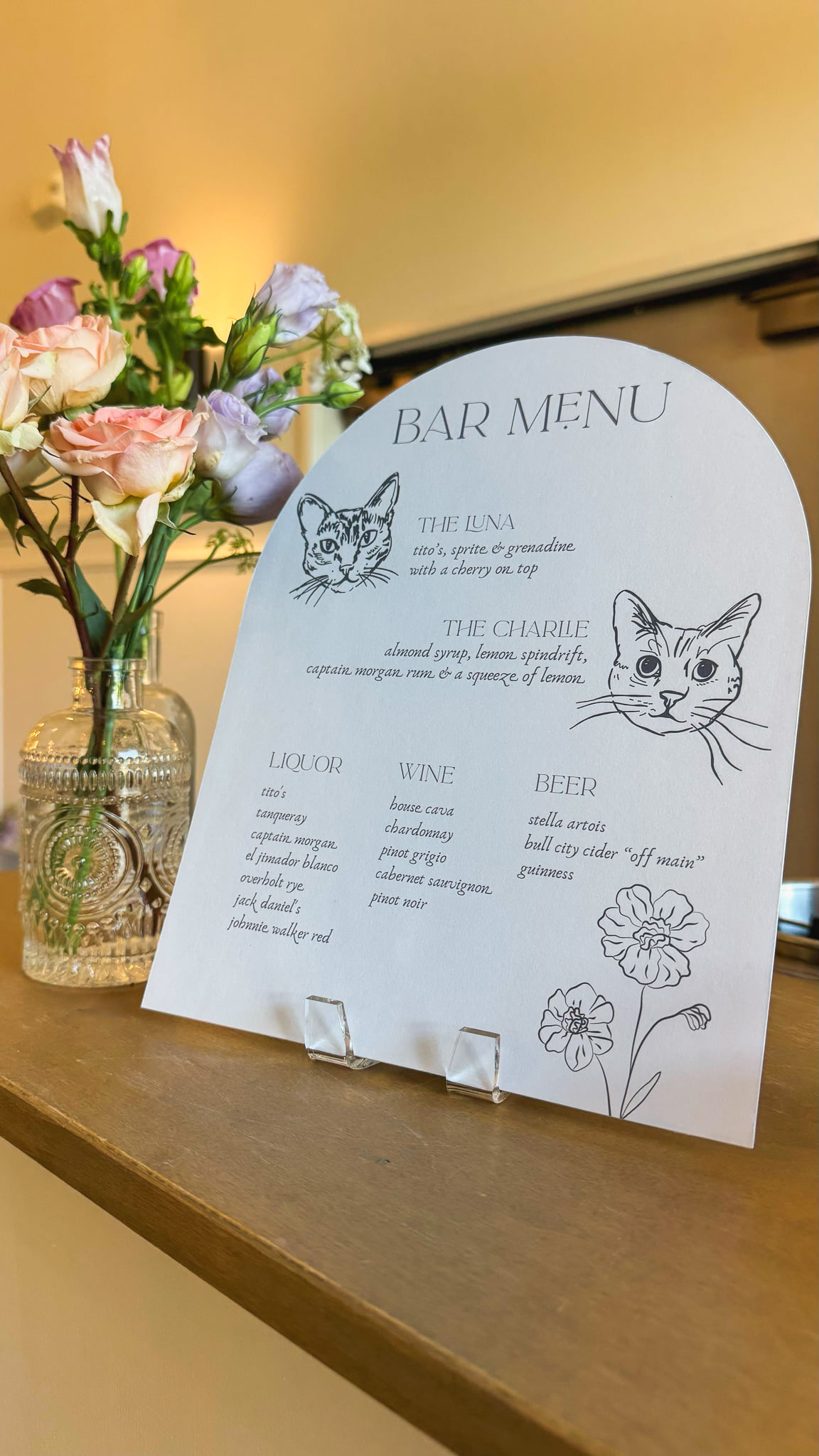 Bar menu sits on a bar with florals 