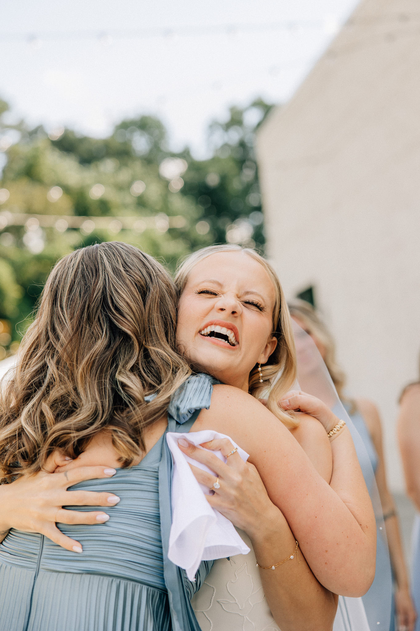 The bride hugs her bridesmaid
