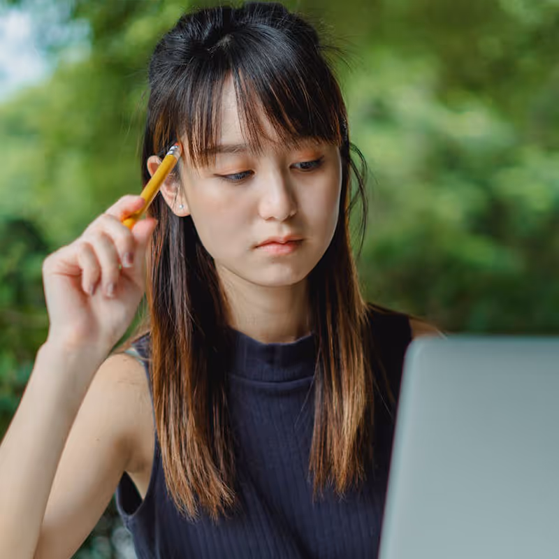 年轻女子聚精会神地看着笔记本电脑