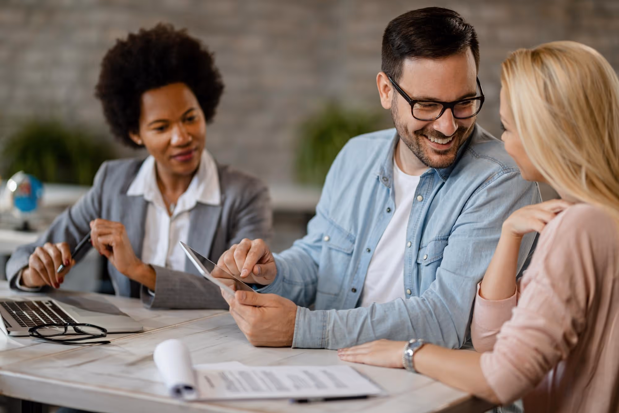Couple reviewing paperwork with advisor about employee health insurance in Germany