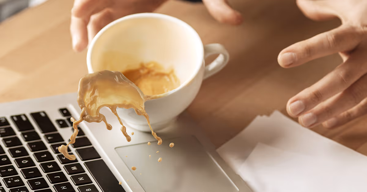 Coffee spill damaging laptop in shared workspace