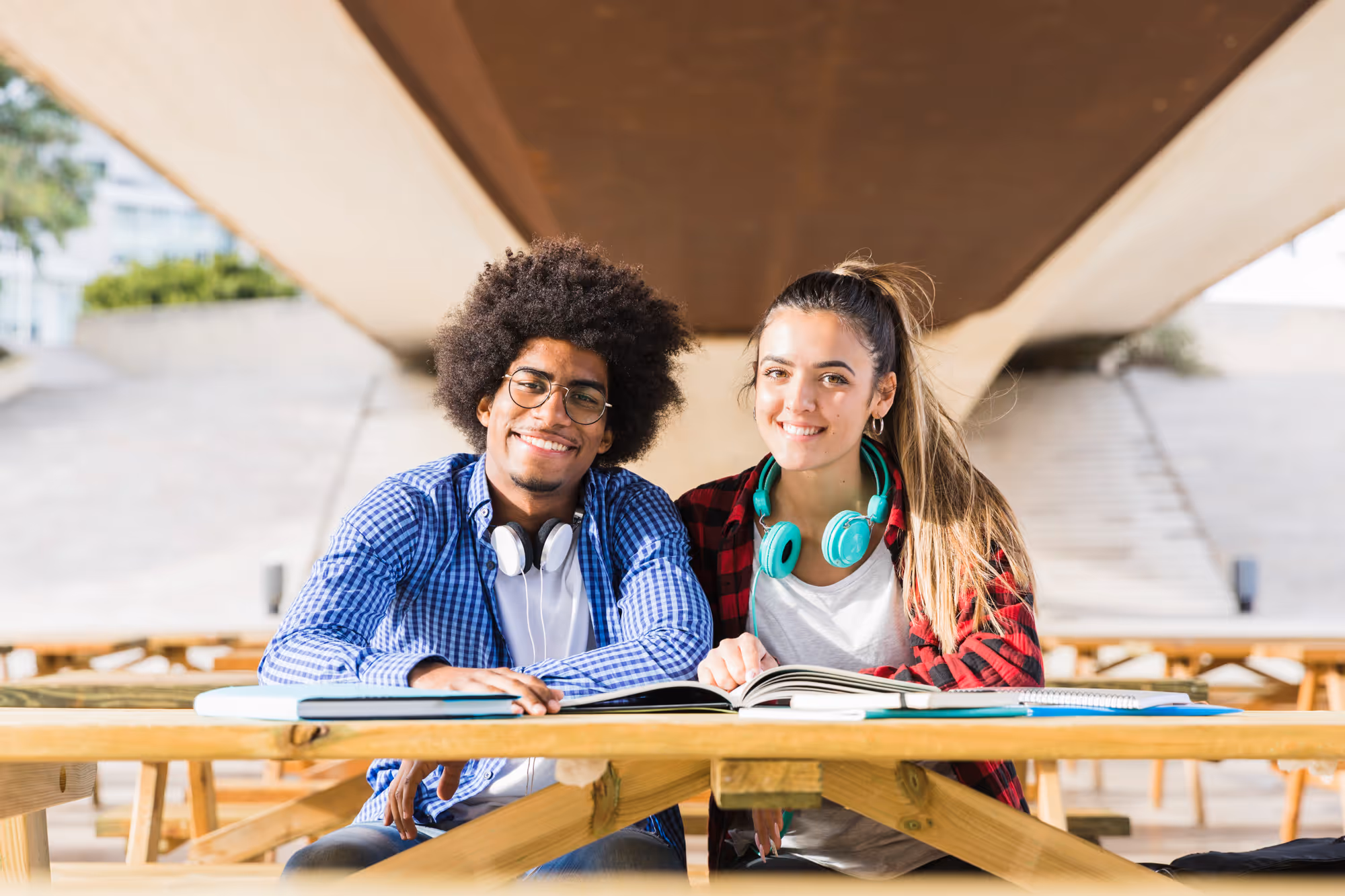 Two students smiling at a table filled with public insurance applications