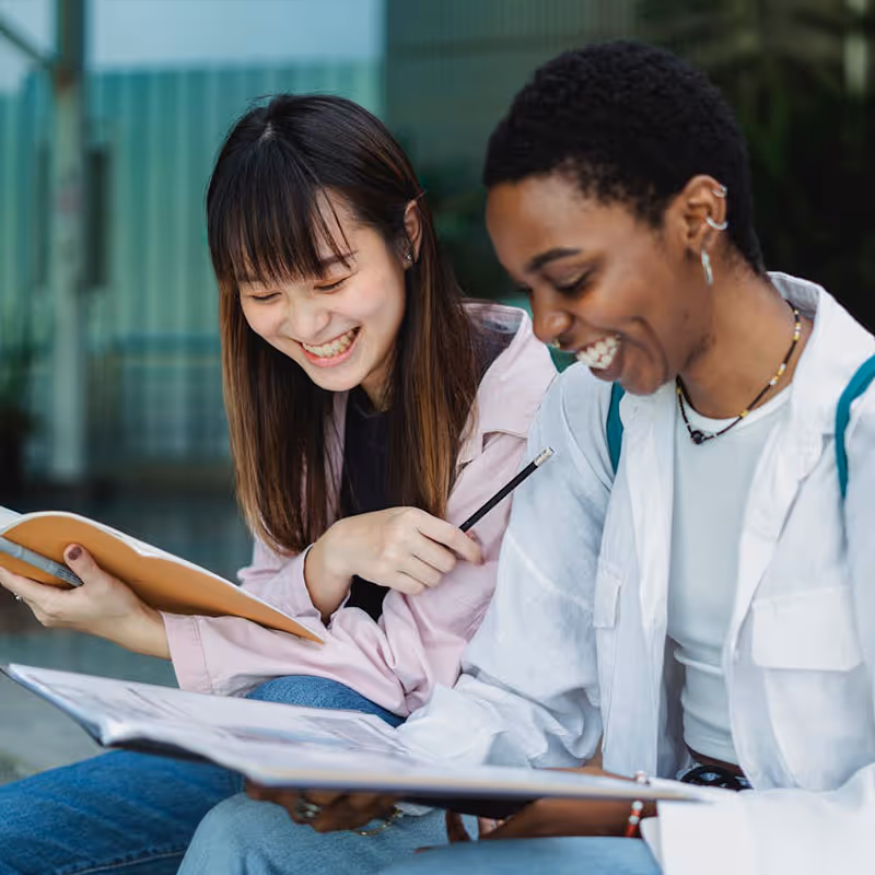 Two students talking and looking over notes