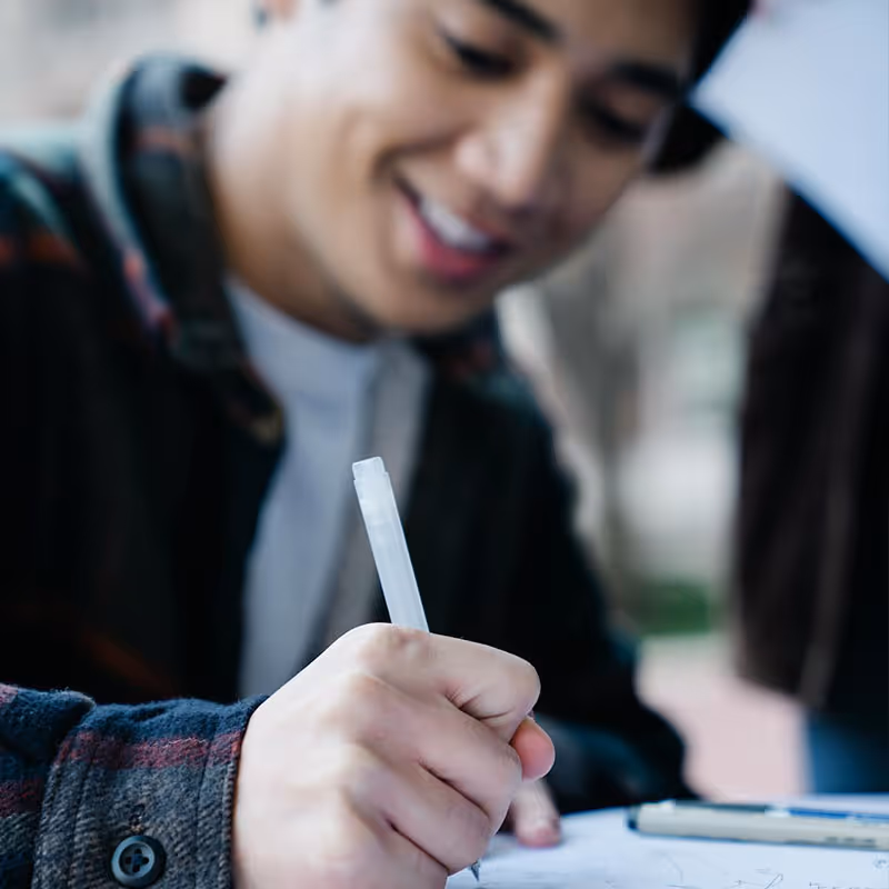 Young man smiling and filling out a form