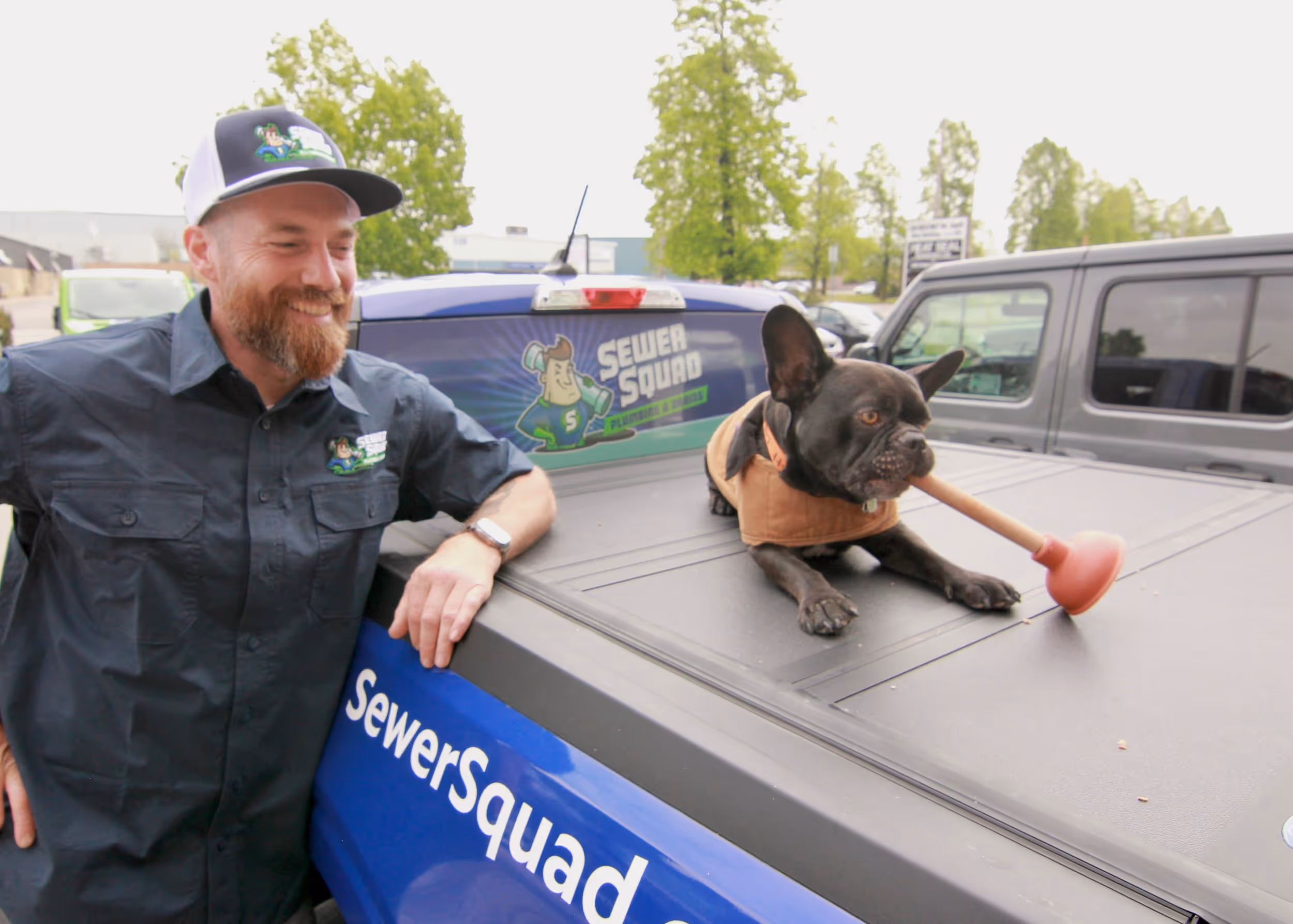 a man with hat next to the truck and a dog is on the truck