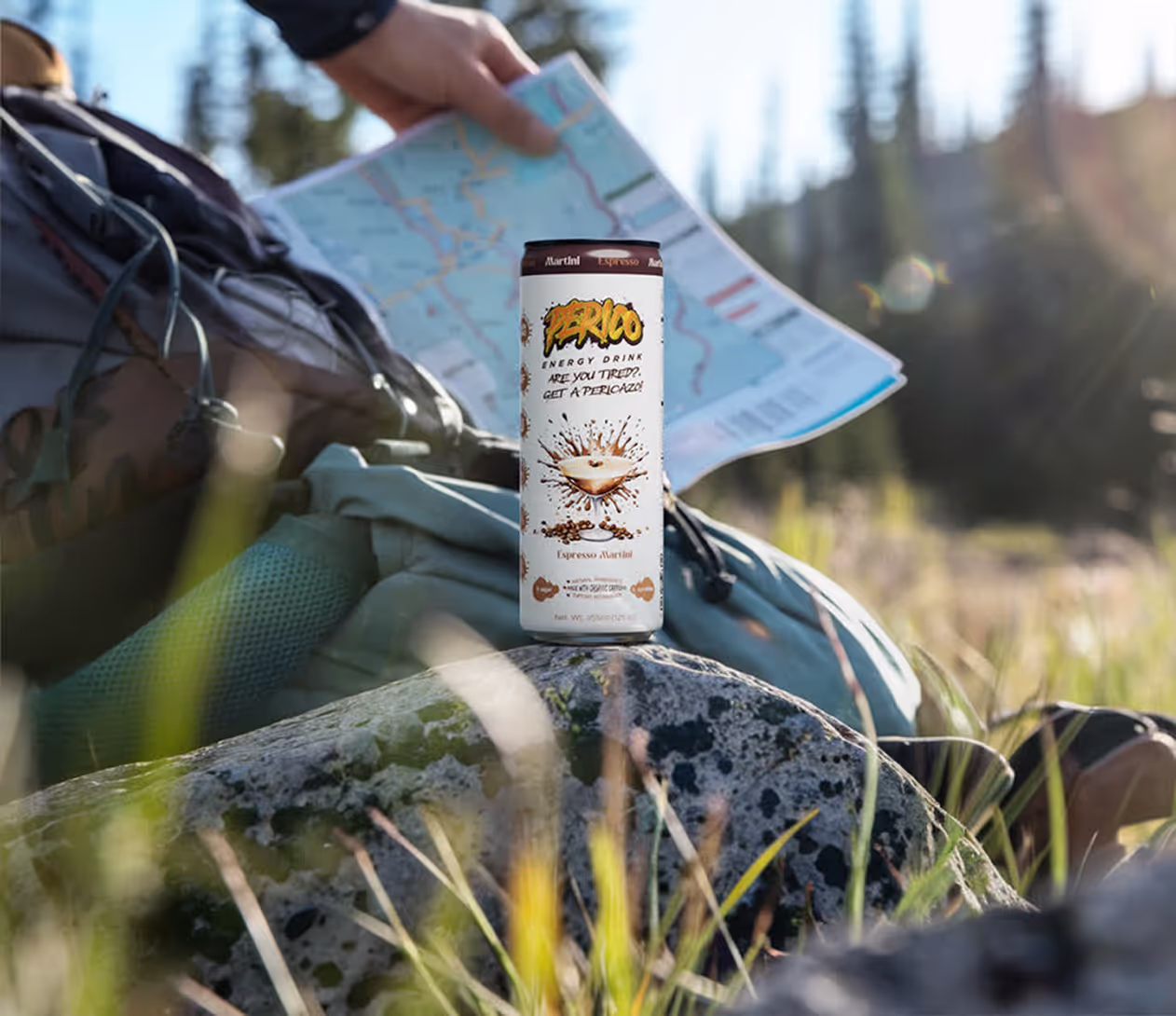 Espresso Alazté Perico Energy Drink resting on a rock beside a backpack and map in the mountains, highlighting its clean ingredients, organic caffeine, and zero junk formula—ideal for outdoor adventures, hiking, and long treks. 