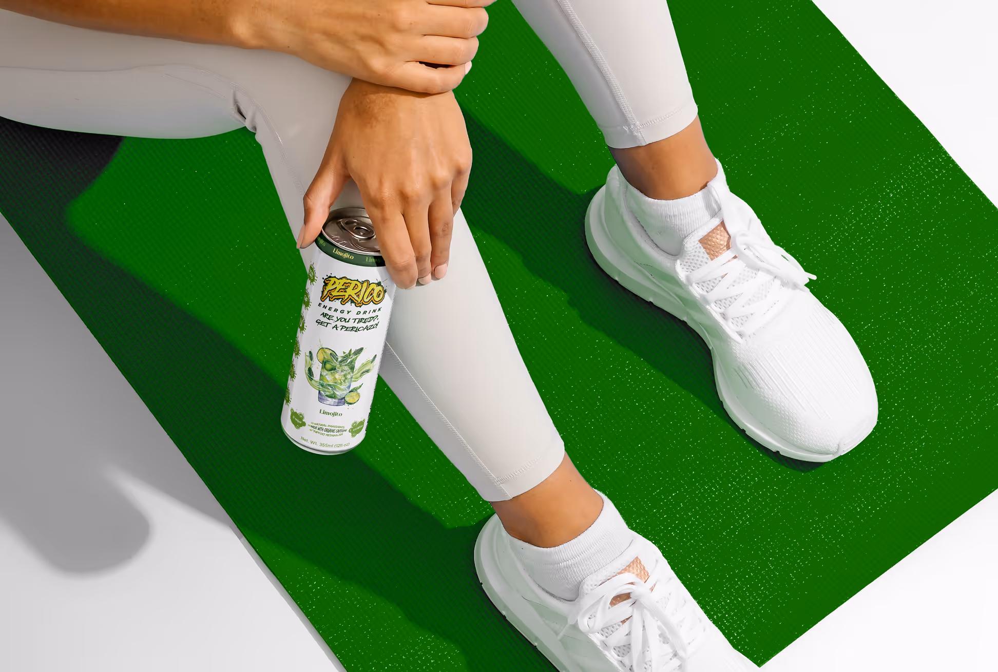 Perico Limojito energy drink held during a workout, placed on a green yoga mat to emphasize wellness, hydration, and active lifestyle benefits.
