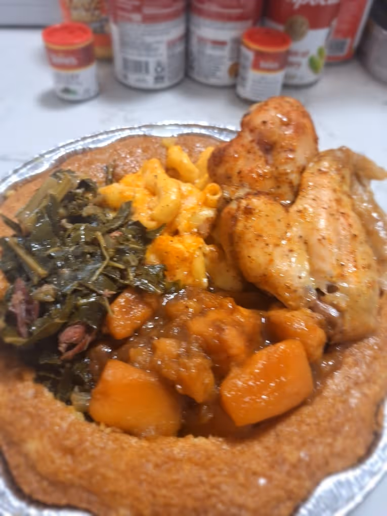 A plate of food with chicken, macaroni and cheese, and greens.