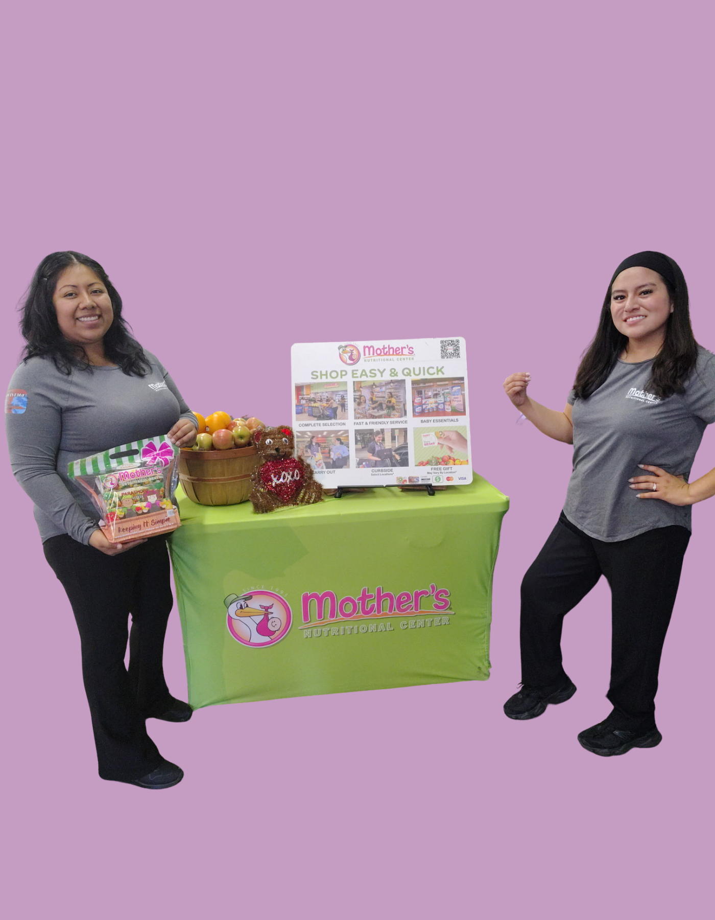 Volunteers with KAUSE stand at a booth to help mothers
