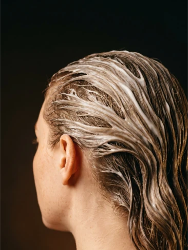 Mulher de costas com cabelo loiro molhado